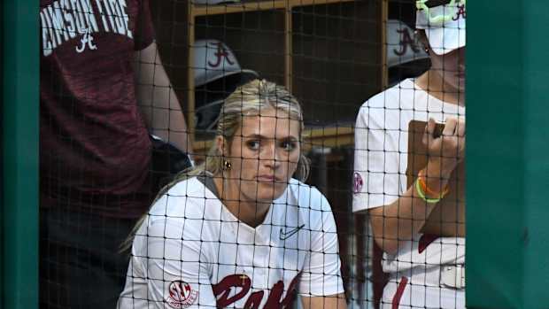 Alabama pitcher Montana Fouts (14) wears a brace on her left knee as she watches from the dugout as the Crimson Tide played Long Island University Friday, May 19, 2023, at Rhoads Stadium in the Tuscaloosa Regional of the NCAA Tournament.